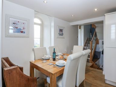 A dining room with a table set for dinner at Eglwys St Cynfil Penrhos near Pwllheli
