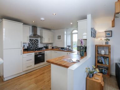 A kitchen with modern appliances and wooden countertops at Eglwys St Cynfil in Penrhos near Pwllheli