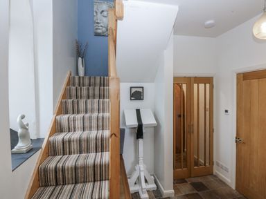 A hallway with stairs and a sculpture at Eglwys St Cynfil Penrhos near Pwllheli