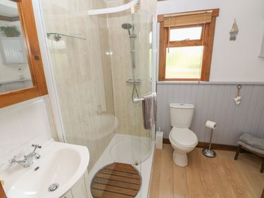 A bathroom with a sink toilet and shower at Timbertwig Lodge in Lamphey near Pembroke