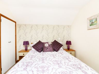 A bedroom with a bed pillow lamps and a closet at The Shippon Near Launceston