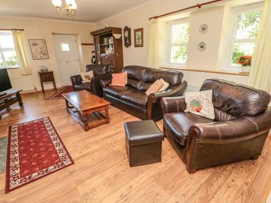 A living room with leather sofas a wooden coffee table and a television at Drovers Rest in Otterburn