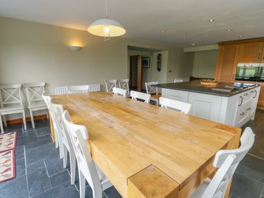 A dining room with a large table and chairs at Chapel House Elim near Llanddeusant