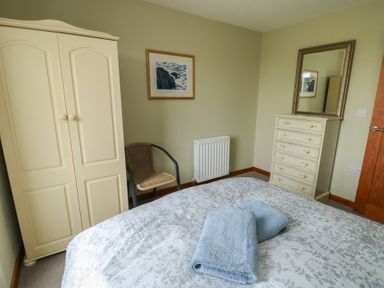 A bedroom with a bed and wardrobe at Chapel House Elim near Llanddeusant