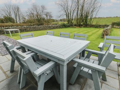 A garden with a table and chairs at Chapel House Elim near Llanddeusant