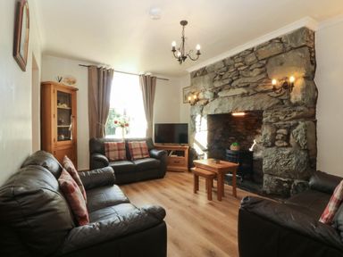 A living room with sofas and a fireplace at Tyddyn in Dyffryn Ardudwy