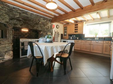 A kitchen with a table and chairs at Tyddyn in Dyffryn Ardudwy