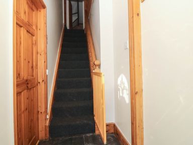 A hallway with stairs leading to an upper level at Tyddyn in Dyffryn Ardudwy