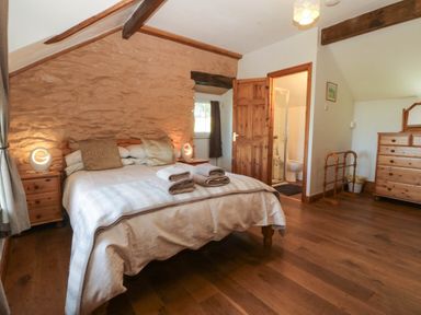 A bedroom with a bed and wooden furniture at Tyddyn in Dyffryn Ardudwy