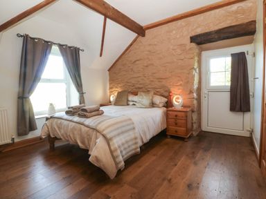 A bedroom with a bed and bedside table at Tyddyn in Dyffryn Ardudwy