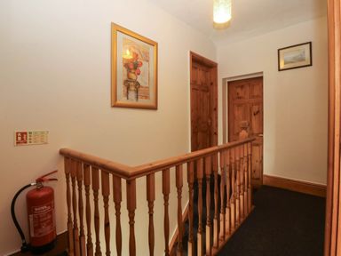 A hallway with a fire extinguisher and painting at Tyddyn in Dyffryn Ardudwy