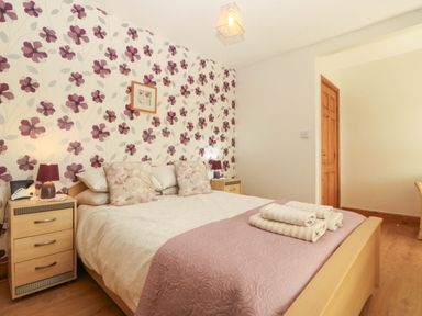 A bedroom with a bed and bedside table at Tyddyn in Dyffryn Ardudwy