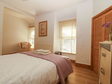 A bedroom with a bed and chair at Tyddyn in Dyffryn Ardudwy