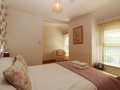 A bedroom with a bed and chair at Tyddyn in Dyffryn Ardudwy