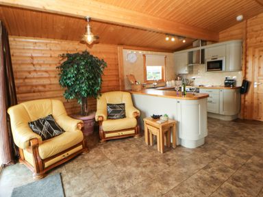 A kitchen with two yellow armchairs and a small wooden table at Cornfield in Northallerton
