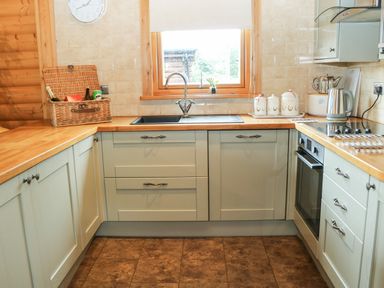 A kitchen with wooden countertops a sink an oven and cabinets at Cornfield in Northallerton