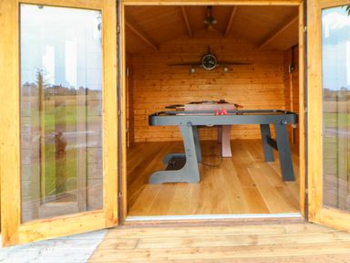 A wooden game room with an air hockey table and a foosball table at Cornfield in Northallerton