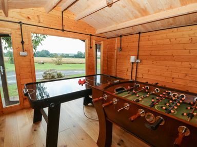 A wooden game room with air hockey and foosball tables at Cornfield in Northallerton