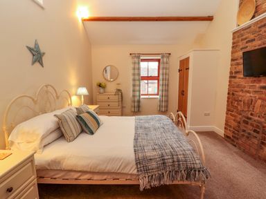 A bedroom with a bed and dresser at The Old Bothy Bolton Low Houses near Wigton