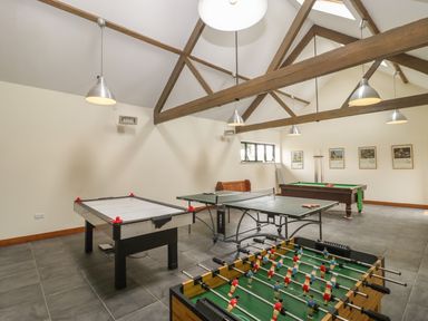 A game room with foosball table air hockey table ping pong table and pool table at Corner Barn in Winterborne Stickland