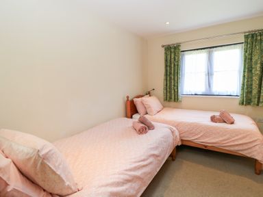 A bedroom with two single beds at Corner Barn in Winterborne Stickland