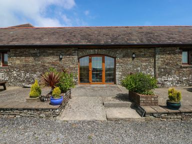 An entrance with double doors and potted plants at The Dairy in Penuel near Llanmorlais