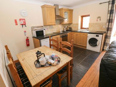 A kitchen with a table and chairs at The Dairy in Penuel near Llanmorlais