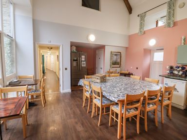 A dining area with wooden chairs and tables covered with blue patterned tablecloths at Greyhound Barn Barnsley near Cirencester