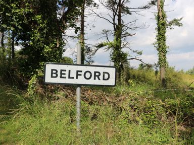A road sign that says belford with trees and grass behind it at Stable Cottage in Belford near Bamburgh