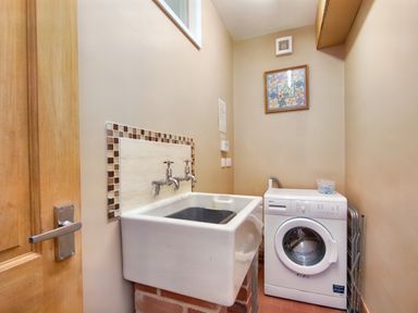 A utility room with a laundry sink and washing machine at Pen Y Gaer in Llannefydd near Abergele and Denbigh