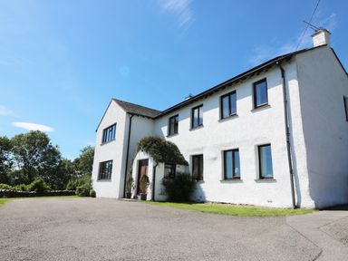 A large white two-story house with multiple windows and a paved driveway at Ghyll Bank House Staveley near Windermere