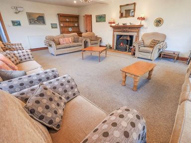 A living room with sofas and a fireplace at Ghyll Bank House Staveley near Windermere