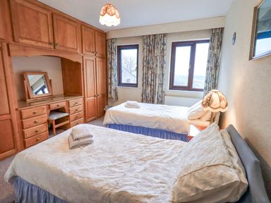 A bedroom with two beds and a desk at Ghyll Bank House Staveley near Windermere