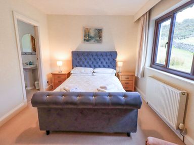 A bedroom with a bed and bedside tables at Ghyll Bank House Staveley near Windermere