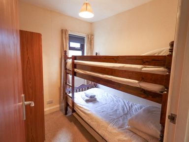 A bedroom with a bunk bed and sheets at Ghyll Bank House in Staveley near Windermere