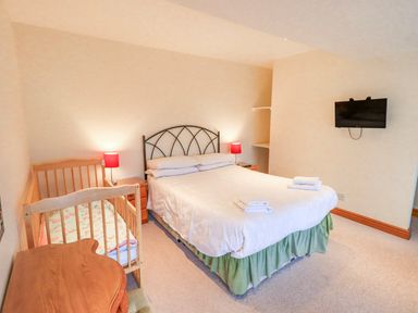 A bedroom with a double bed and crib at Ghyll Bank House Staveley near Windermere