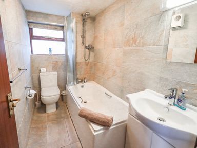 A bathroom with a bathtub and sink at Ghyll Bank Bungalow Staveley near Windermere