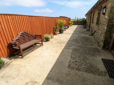 An outdoor area with benches and planters at The Stall in Penuel near Llanmorlais