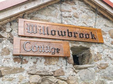 A wooden sign with the words Willowbrook Cottage mounted on a stone wall at Willowbrook Cottage in Askill County Leitrim