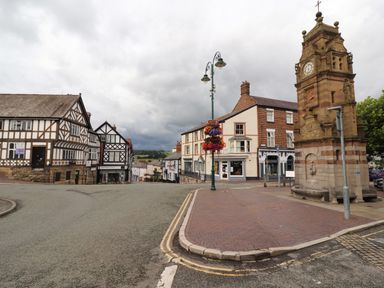 A street corner with a clock tower and half-timbered buildings at Maestyddyn Farm House Clawddnewydd near Ruthin