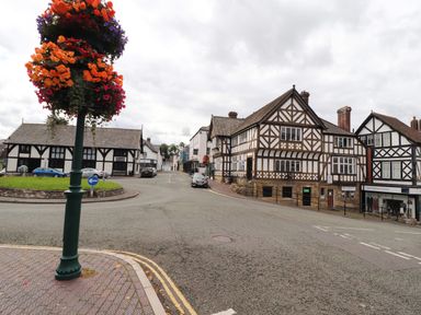 A street with timber framed buildings and hanging flower baskets at Maestyddyn Farm House Clawddnewydd near Ruthin