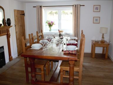 A dining room with a table set for dinner at Manor Farm Cottage Swaffham