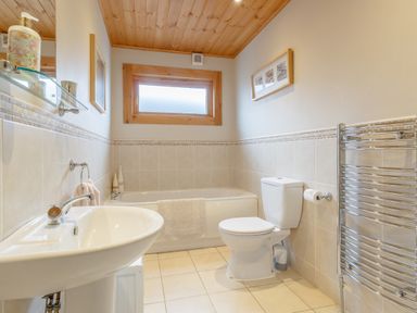 A bathroom with a sink toilet bathtub and towel radiator at Jamaal Lodge in South Broomhill near Amble