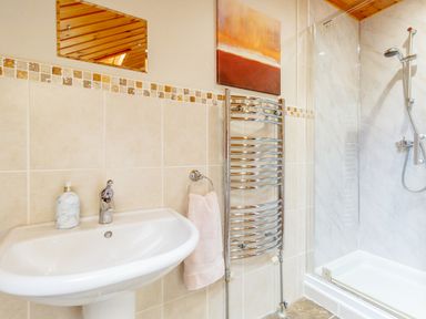 A bathroom with a sink towel rack and a shower at Jamaal Lodge in South Broomhill near Amble