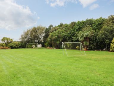 A grassy field with two soccer goals and trees in the background at Sutton Cottage in Ballysheen near Rosslare Harbour County Wexford