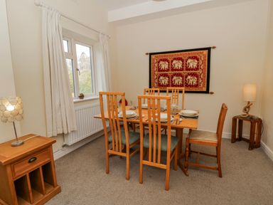 A dining room with a table set for dinner at Gardener's Cottage in Llanwrthwl near Rhayader