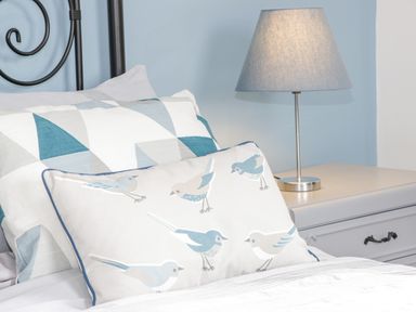 A bed with pillows and a bedside table with a lamp at Mountain View in Conwy