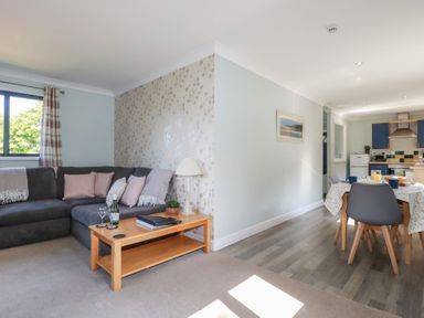 A living room with a sofa and dining area at The Station Flat in St Newlyn East near Newquay