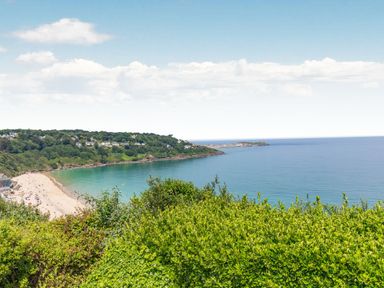A coastal view with a beach a bay and houses on a hill at Apartment 1 Llewellan in St Ives