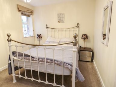 A bedroom with a bed and nightstand at Beach View in Benllech near Red Wharf Bay